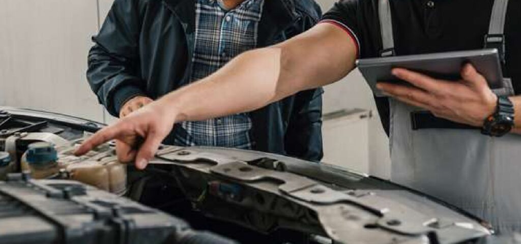 hand pointing out something on a car engine