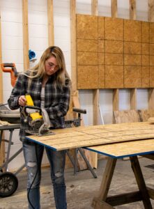 Construction student cutting plywood