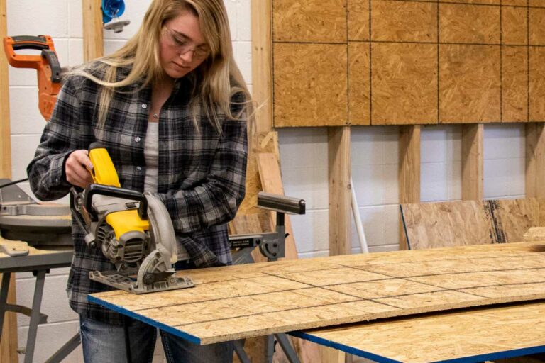 Construction student cutting plywood