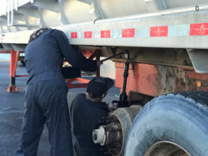 two students working on a semi truck