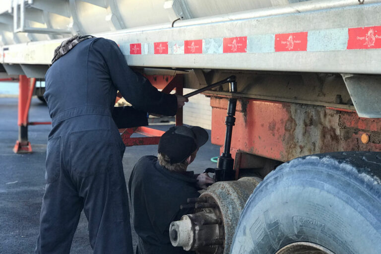 two students working on a semi truck